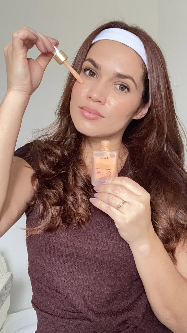 Mulher aplicando o NanoGlow com o conta-gotas no rosto